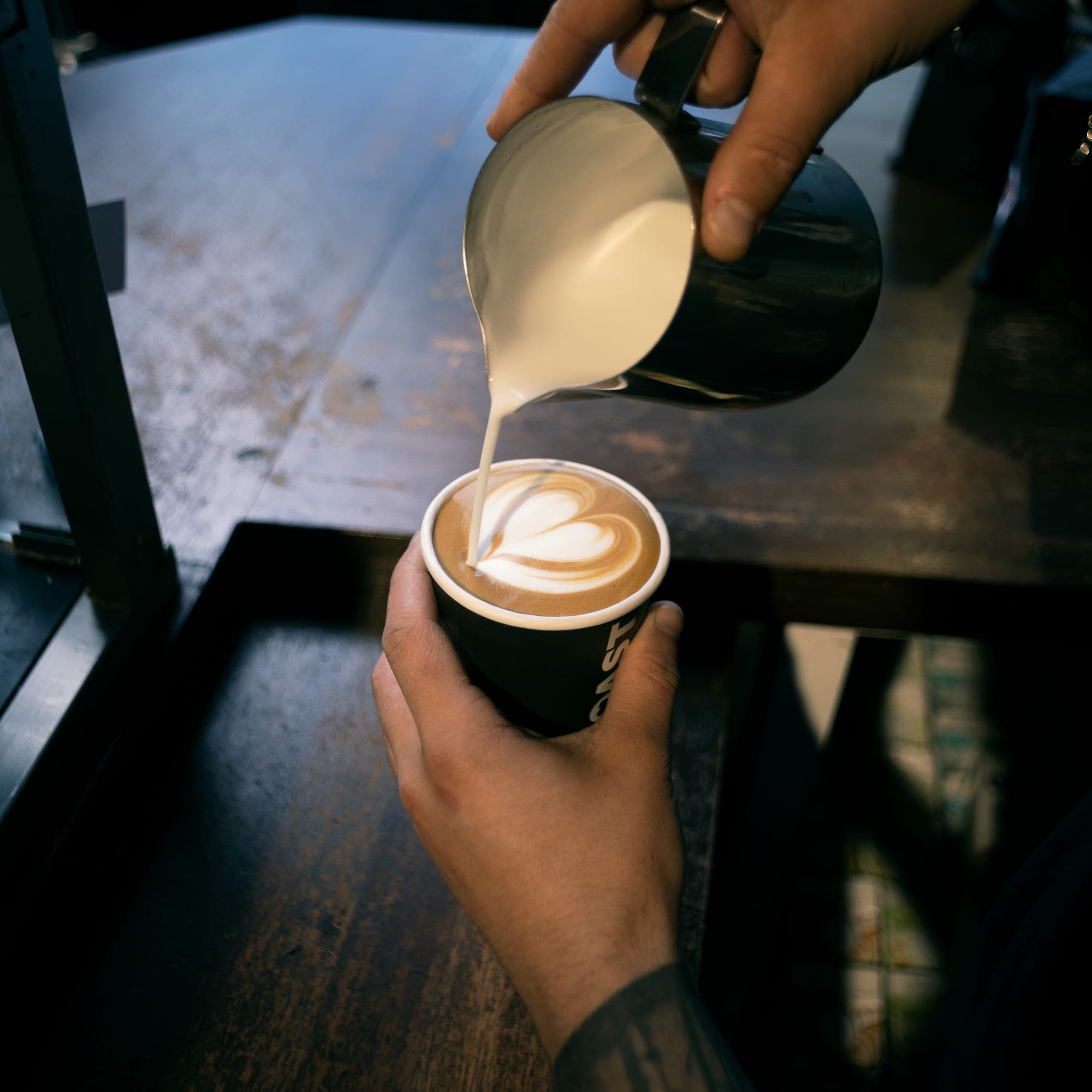 A TOAST barista pouring latte art